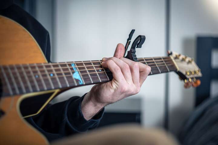 Man playing guitar with capo